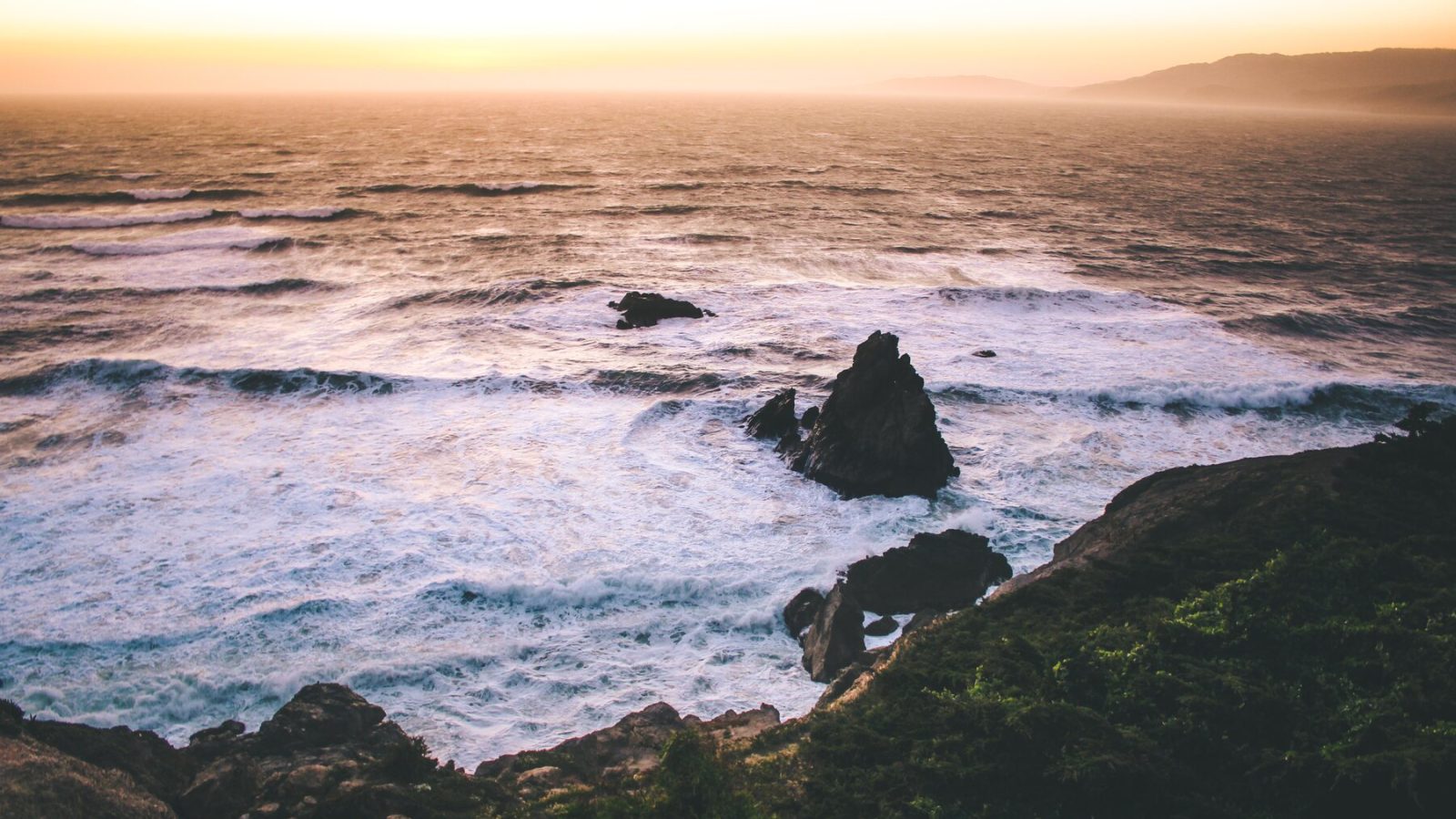 Pacific surf breaking around rocks below the Lands End headland in San Francisco